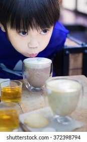 Little Asian Boy Drinking Hot Chocolate In Cafe