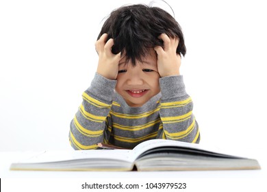 Little Asian boy frustrated over homework with his both hand on head.. Boy studying at table isolated on white background. - Powered by Shutterstock