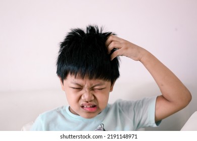 A Little Asian boy itchy his hair. - Shutterstock ID 2191148971