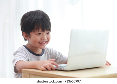 Little Asian Boy With Laptop Computer Or Notebook At Home. Learning Concept.