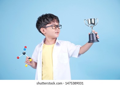 Little Asian Boy Learning Chemical In Science With White Blouse Coat, Isolated On Blue Background