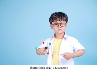 Little Asian Boy Learning Chemical In Science With White Blouse Coat, Isolated On Blue Background