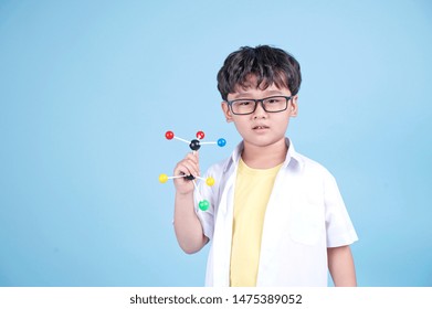 Little Asian Boy Learning Chemical In Science With White Blouse Coat, Isolated On Blue Background