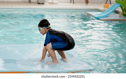 Little Asian Boy On Swimming Pool. Kid Learning To Swim. Selective Focus. Copy Space.