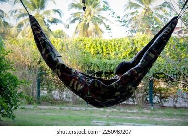 Little asian boy resting in comfortable hammock at green garden - Shutterstock ID 2250989207