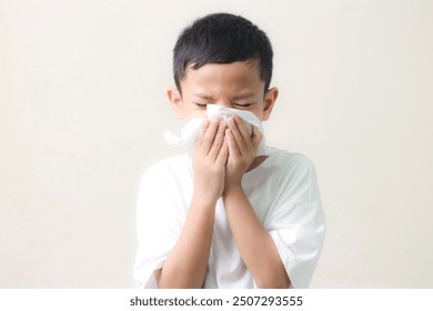 Little asian boy sick and sad with sneezing on nose and cold cough on tissue paper becauseweak or virus and bacteria. cold allergies or illness, health, - Powered by Shutterstock