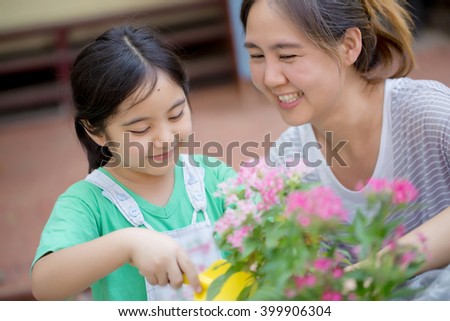 Little Asian child and mother planting flower together at home