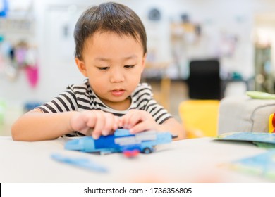 Little Asian Child Playing With Lots Of Colorful Plastic Blocks Stay At Home.Kid Boy Making Airplane Toy Colorful Toy Block Having Fun With Building.Recreation, Motor Skill,Child Development, Brain.
