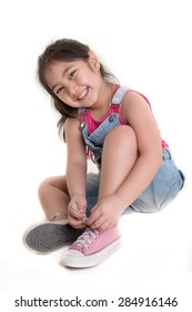 Little Asian Child Practices To Tying Her Shoes On Isolated Background