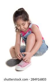 Little Asian Child Practices To Tying Her Shoes On Isolated Background