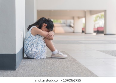 Little Asian Child Sitting And Waiting Someone. Depressed Asian Girl. 