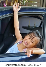 Little Asian Child Waving Hand In A Car