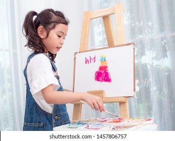 Little Asian Cute Girl 6 Years Old Playing Watercolors Painting Cake For Happy Birthday On White Paper. Learning And Education Of Kid.