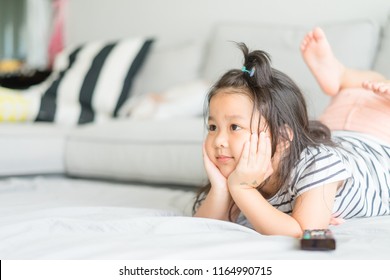  Little Asian Cute Girl Watching Tv On Her Sofa Alone.