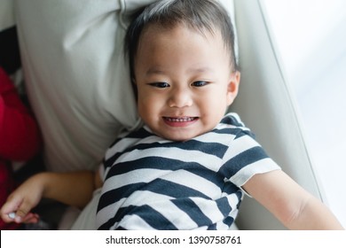 Little Asian Cute Toddler Boy Watching Tv On His Sofa And Looking Up Alone.