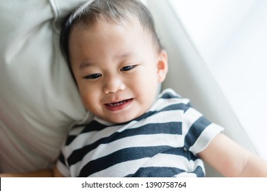 Little Asian Cute Toddler Boy Watching Tv On His Sofa And Looking Up Alone.