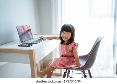 Little Asian Female Kid Using Laptop At Home