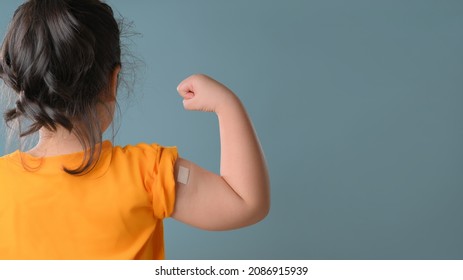 Little Asian Girl With Bandage Plaster On Her Arm After Covid-19 Vaccination. Injection Covid Vaccine, Healthcare For Children