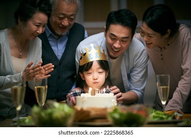 little asian girl blowing candles while three generation family celebrating her birthday at home - Powered by Shutterstock