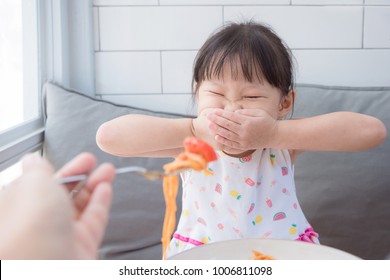 Little Asian Girl Close Her Mouth By Hands,refuse To Eat Tomato In Spagethi From Her Mother.Picky Eater Child Concept.