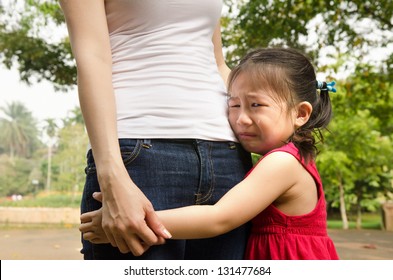 Little Asian Girl Crying And Hugging Her Mother