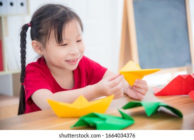 Little Asian Girl Doing Paper Airplane From Paper Folding At School.