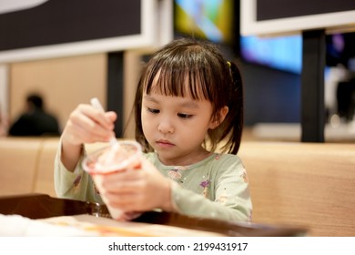 Little Asian Girl Eating Ice Cream At Restaurant. Soft Focus. Copy Space.