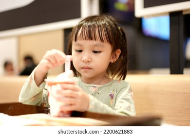 Little Asian Girl Eating Ice Cream At Restaurant. Soft Focus. Copy Space.