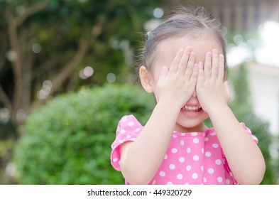 Little Asian Girl Enjoy Playing Hide And Seek Outdoor