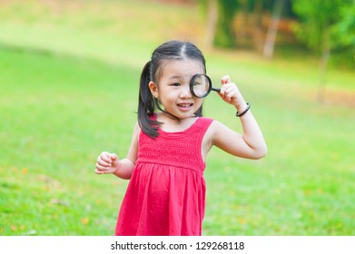 Little Asian Girl Exploring Nature By Magnifier Glass