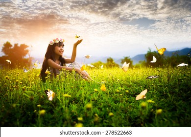Little asian girl in garden with hands up and butterflies - Powered by Shutterstock