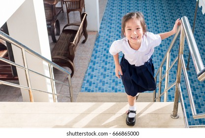 Little Asian  Girl Going Up The Stairs In The School, Uniform