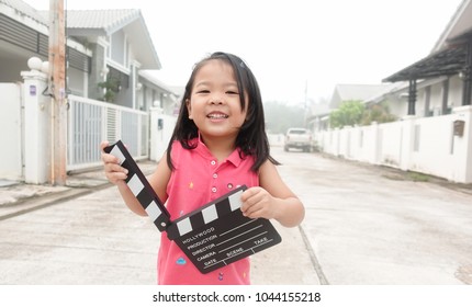 Little Asian Girl Hands Holding Clapper Board For Making Video Cinema In Studio.Kids Movie Production With Clapper Board Or Slate Film Concept.