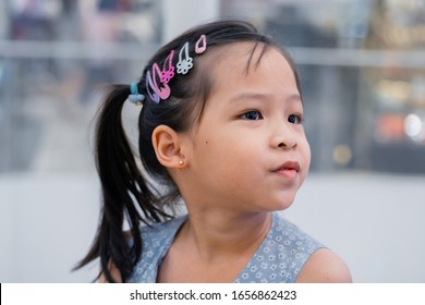 Little Asian Girl Having Ear Piercing Process