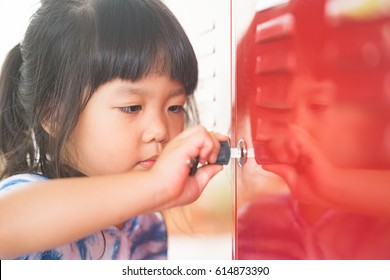 Little Asian Girl Holding The Key And Open Red Cabinet Door.Free Your Mind Awareness Attitude Concept.