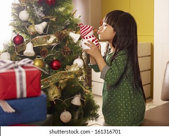 Little Asian Girl Kissing A Toy Snowman.