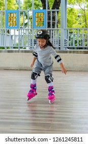 Little Asian Girl Learn How To Skate. Kid Skating Inline Skate.