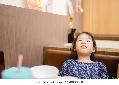 Little Asian Girl Make Boring Face When She Eat Breakfast.Unhappy, Disgusted, Unlike Food In The Morning Concept.Little Asian Girl Child With No Appetite In Front Of The Meal.