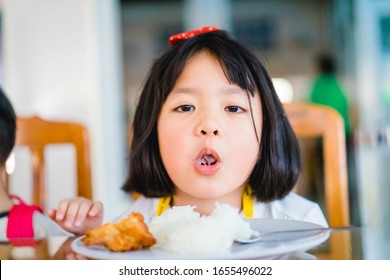 Little Asian Girl Make Boring Face When She Eat Vegetable In Breakfast.Unhappy, Disgusted, Unlike Food In The Morning Concept.Little Asian Girl Child With No Appetite In Front Of The Meal.