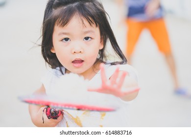 Little Asian Girl Playing Badminton With Her Father In Front Of The House.