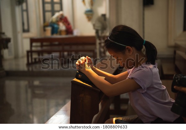 little girl praying in church