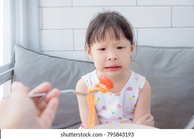 Little Asian Girl Refuse To Eat Tomato In Spagethi From Her Mother,Picky Eater Child Concept.