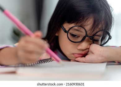 Little Asian Girl Sitting Alone And Looking Out With A Bored Face, Preschool Child Laying Head Down On The Table With Sad Bored With Homework, Spoiled Child