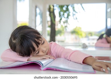 Little Asian Girl Sleeping On The Desk At The Classroom