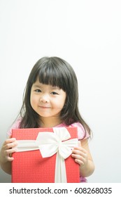 Little Asian Girl Smile And Holding Gift Box On White Background.child Holding Gift Box.