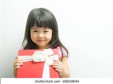 Little Asian Girl Smile And Holding Gift Box On White Background.child Holding Gift Box.