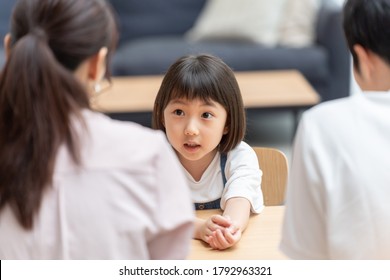 A Little Asian Girl Talking To Her Parents