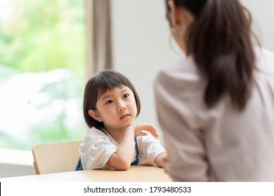 A Little Asian Girl Talking To Her Parents