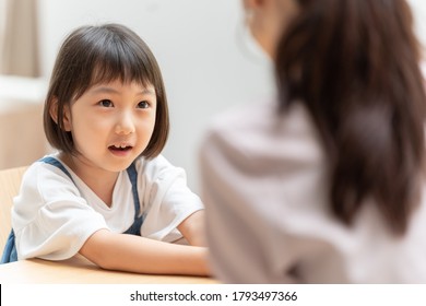 A Little Asian Girl Talking To Her Parents