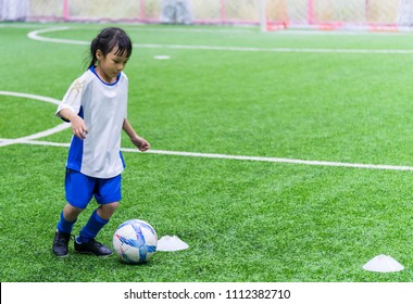 Little Asian Girl Is Training In Indoor Soccer Field